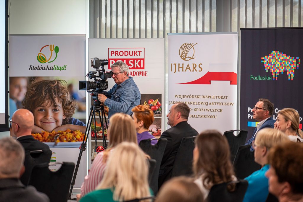 Lokalne media rejestrujące wystąpienia ekspertów podczas białostockiej konferencji dla dyrektorów szkół i producentów.